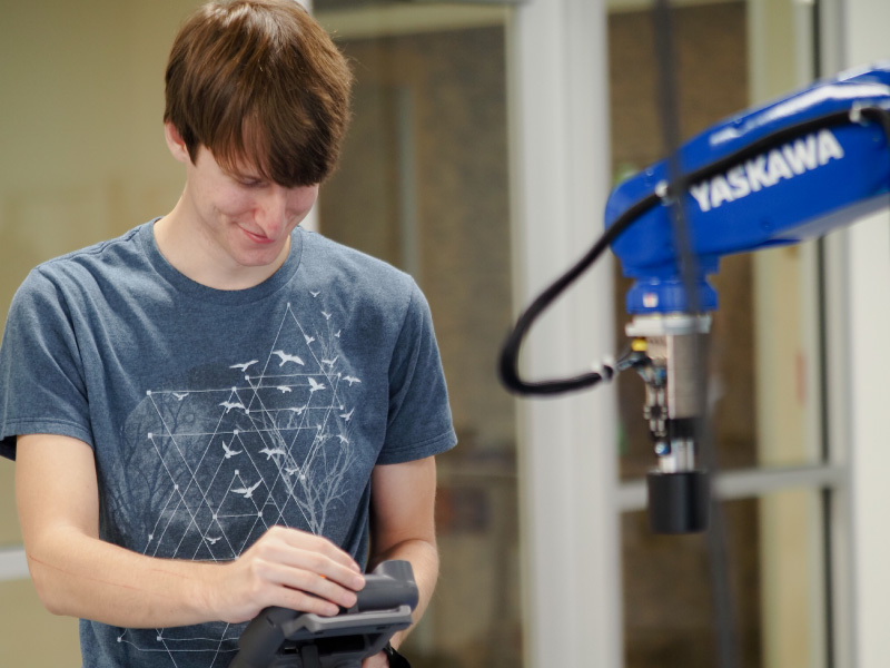 A student using a robot in the engineering technology hub.
