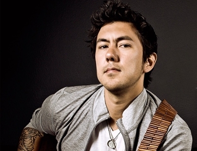 Justin Young, a musician holding a guitar