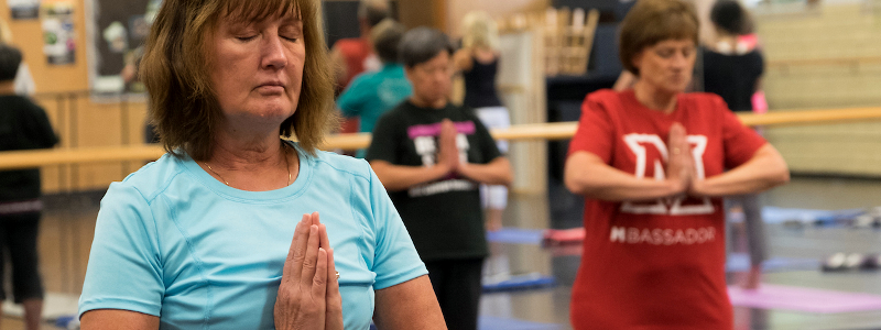 Women doing yoga with hands pressed together