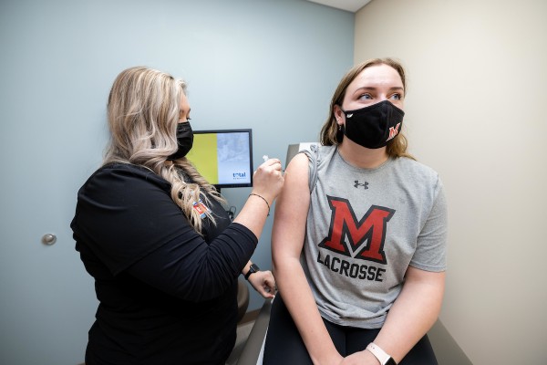 Student getting an immunization by a nurse practitioner