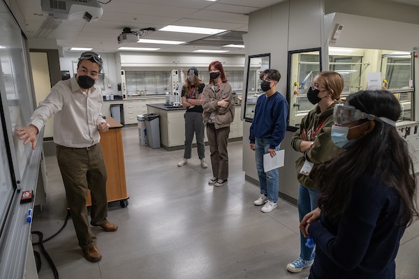 High school students meeting in a science lab on campus with one of the faculty members