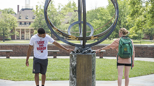Two students outdoors at a campus fountain