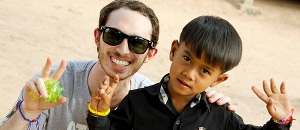 A student poses for a picture with a little boy