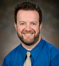 Thomas Webb wearing a blue shirt and yellow tie