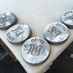 Several small gray disks with the Miami M stamped in