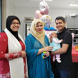 Taskina, her mother, and her husband, along with baby Areeba smiling at the camera