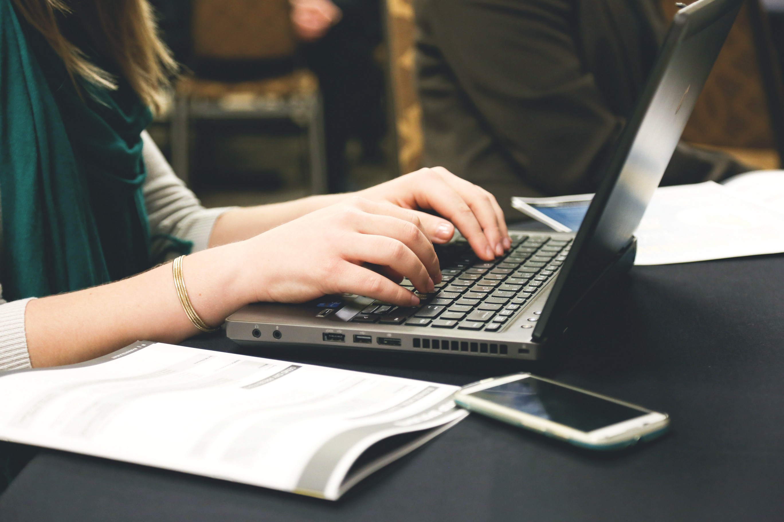 Hands typing on a laptop keyboard