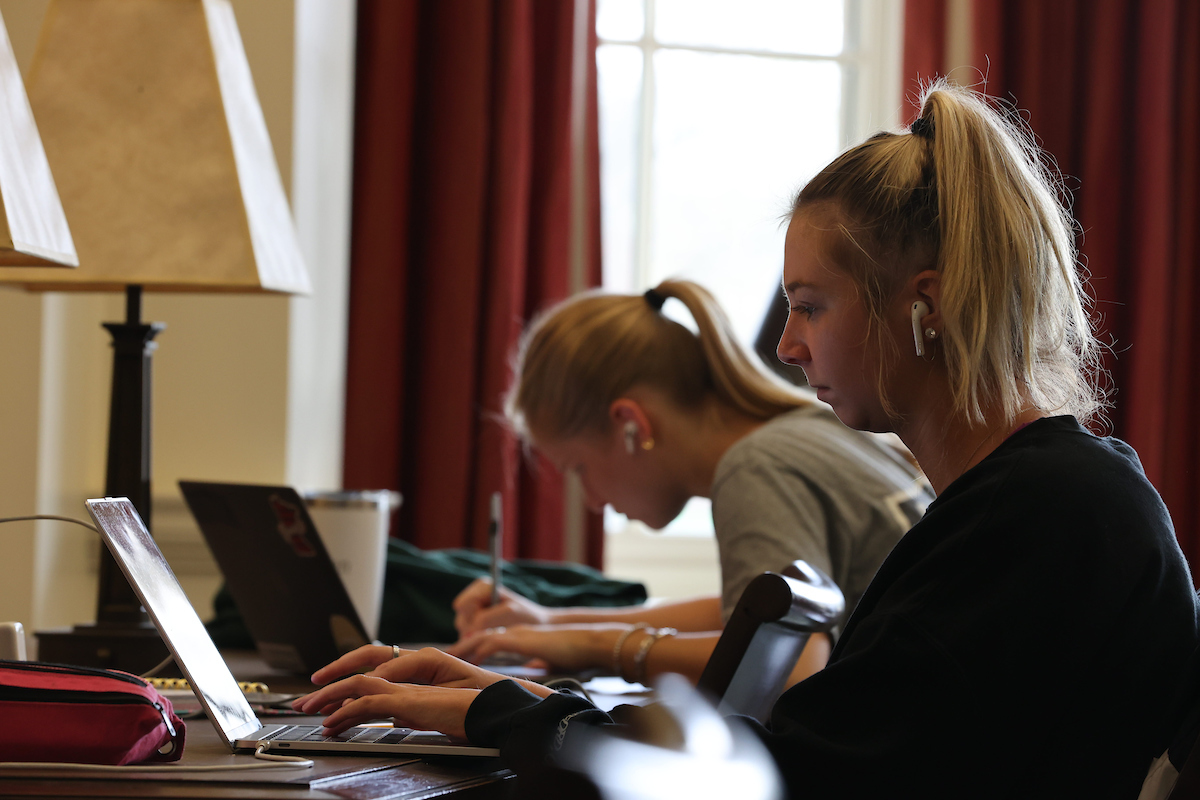 Two female students working at their laptops in the Farmer School of Business