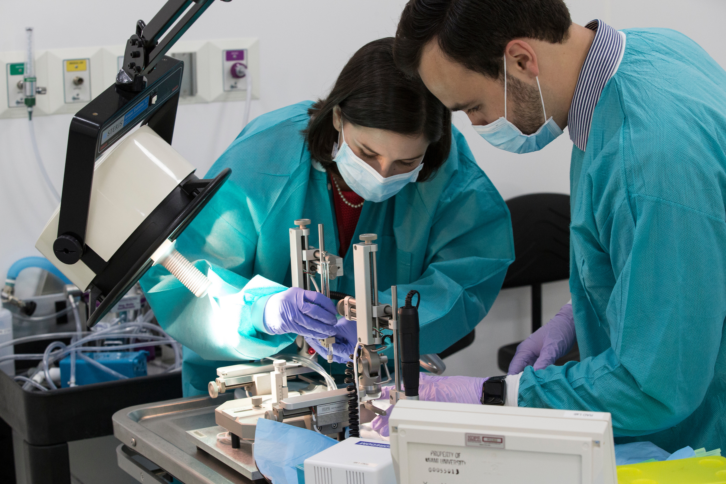 Two students working with scientific equipment in a science lab