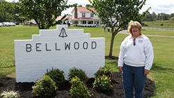 Cindy Hurley standing next to a sign that says Bellwood