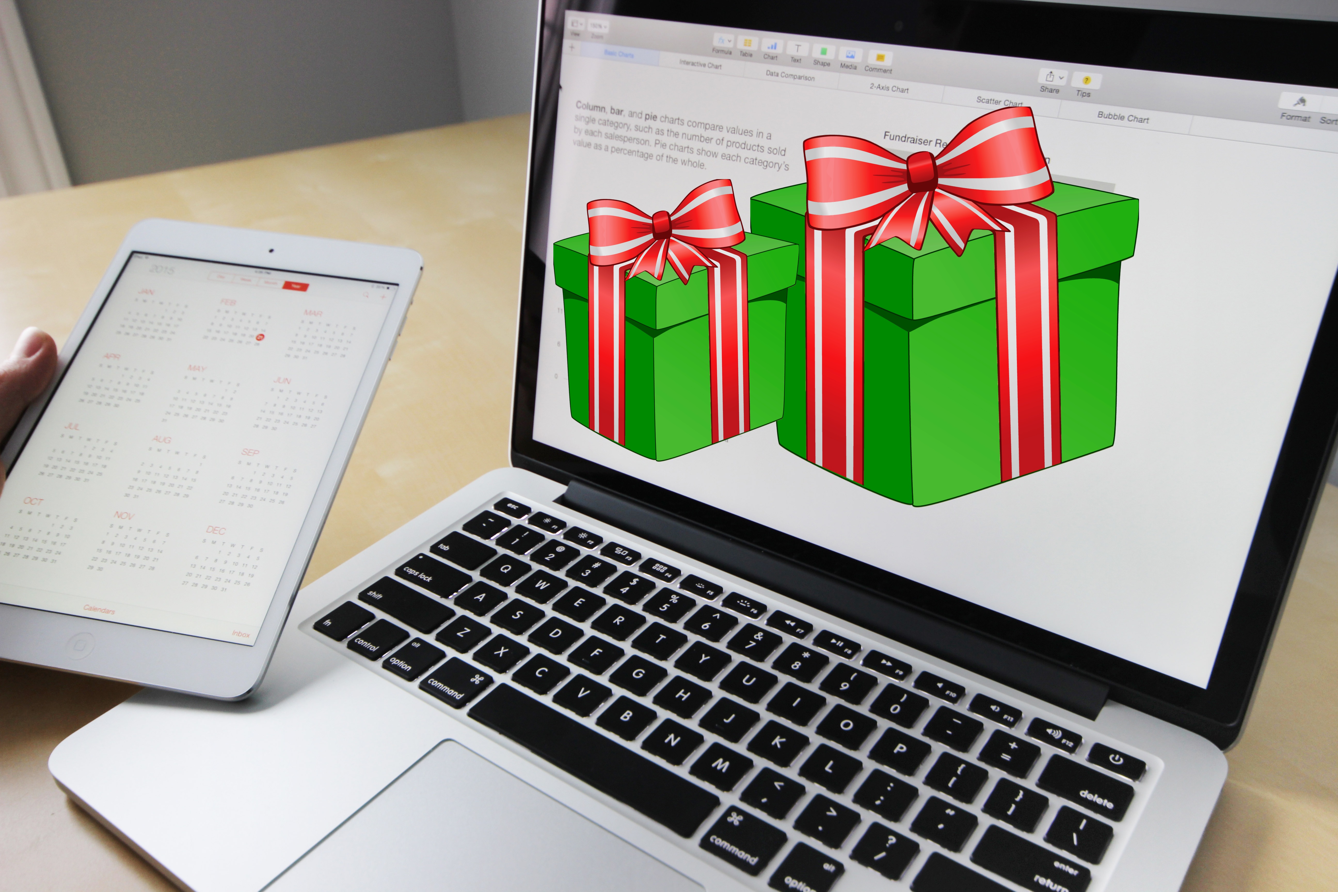 Laptop computer showing two holiday gifts on the screen with green boxes and red and white bows