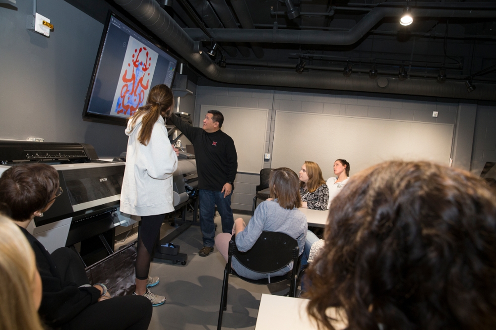 Instructor using projector screen to teach in a class