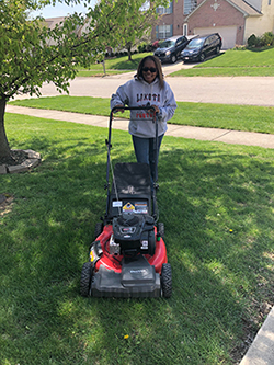 Sharita Massie pushing a lawn mower