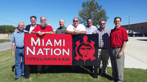 Several people from IT Services and the Miami Tribe standing near a Miami Tribe sign