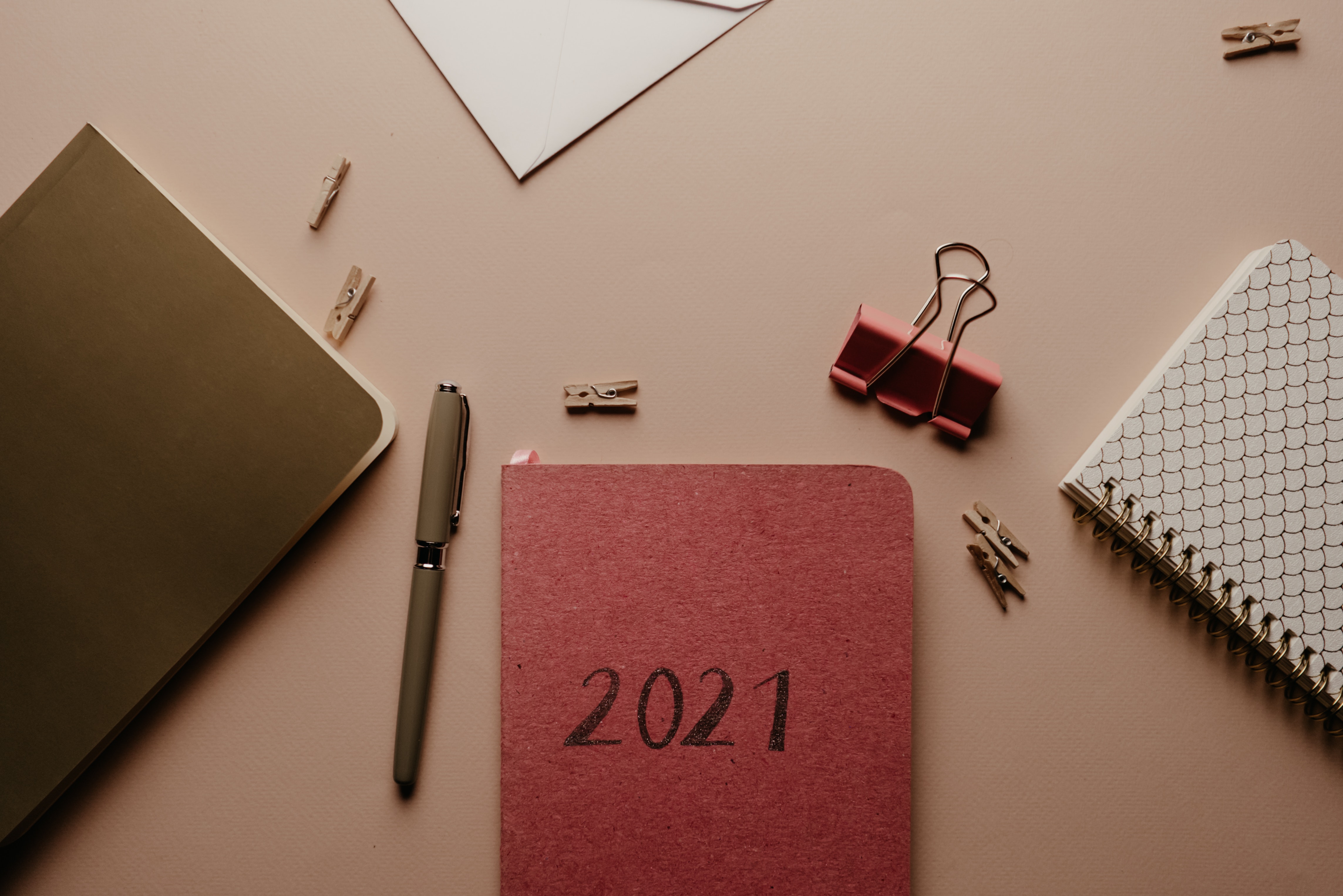 A red booklet labeled 2021 surrounded by office supplies