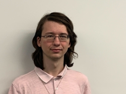 Daniel Lewis headshot. Daniel is a white, male-presenting person wearing glasses with long brown hair.