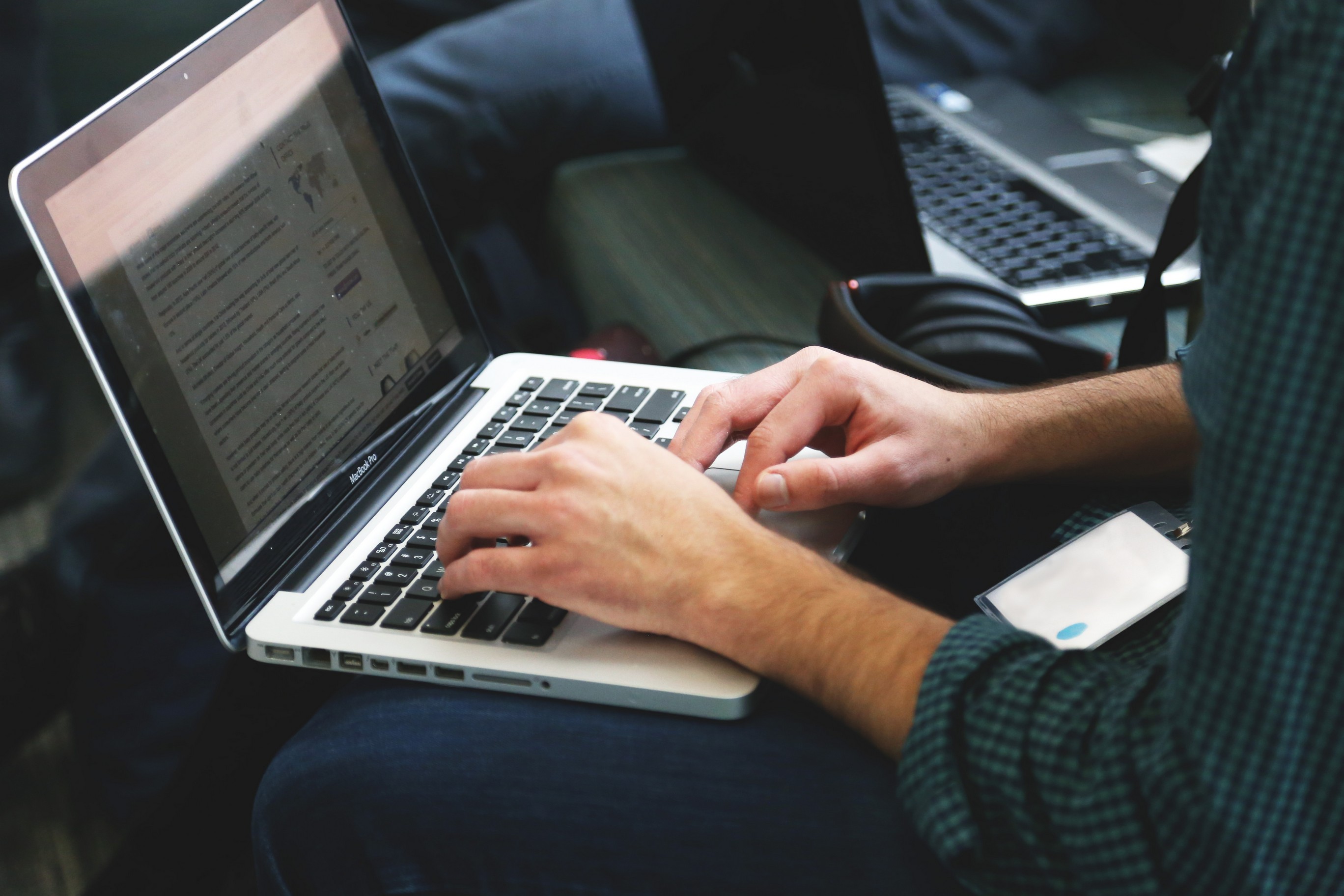 Hands typing on a Mac laptop