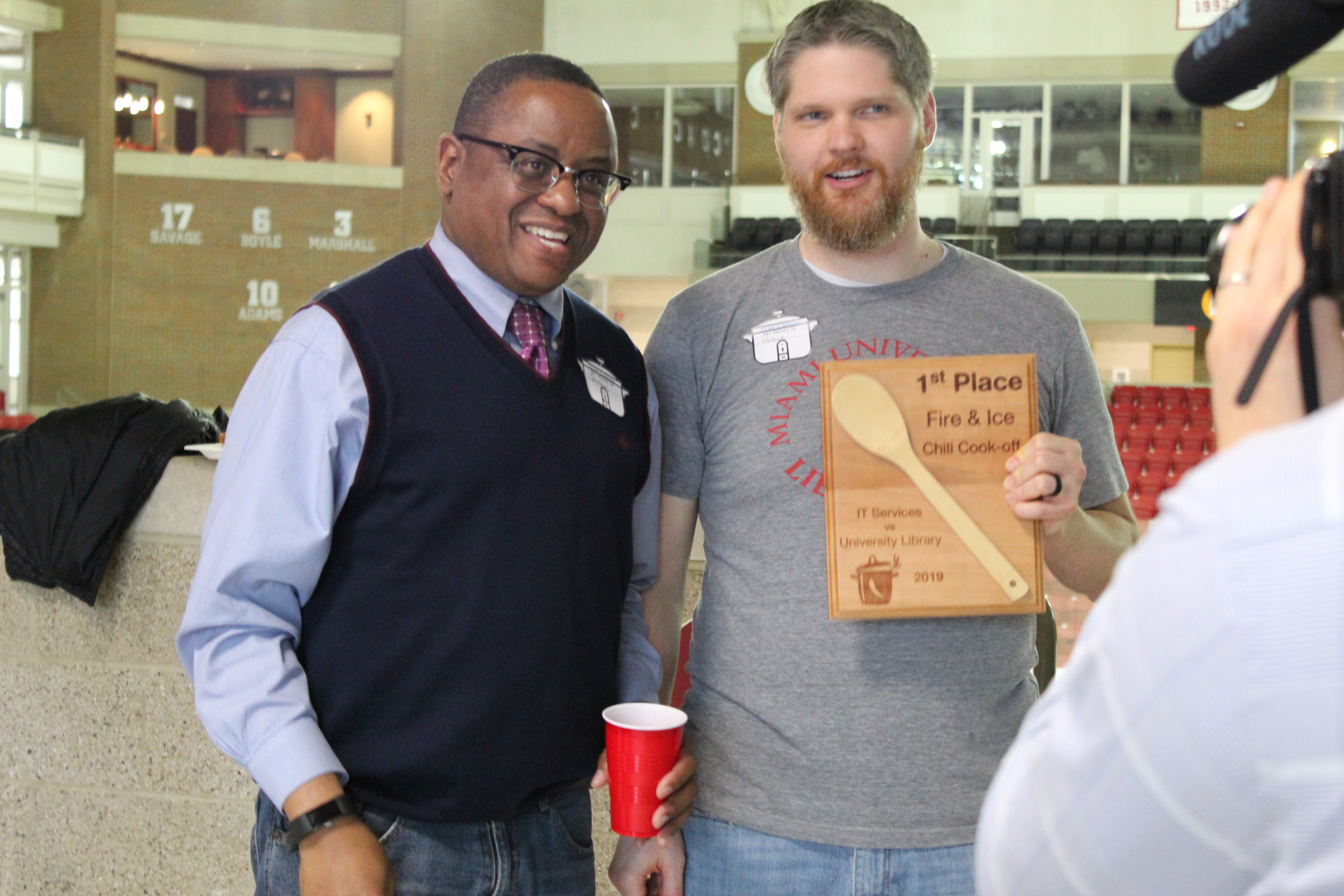 Patrick Hawk and Dean Conley showcase Patrick's chili trophy after he won the 2019 competition