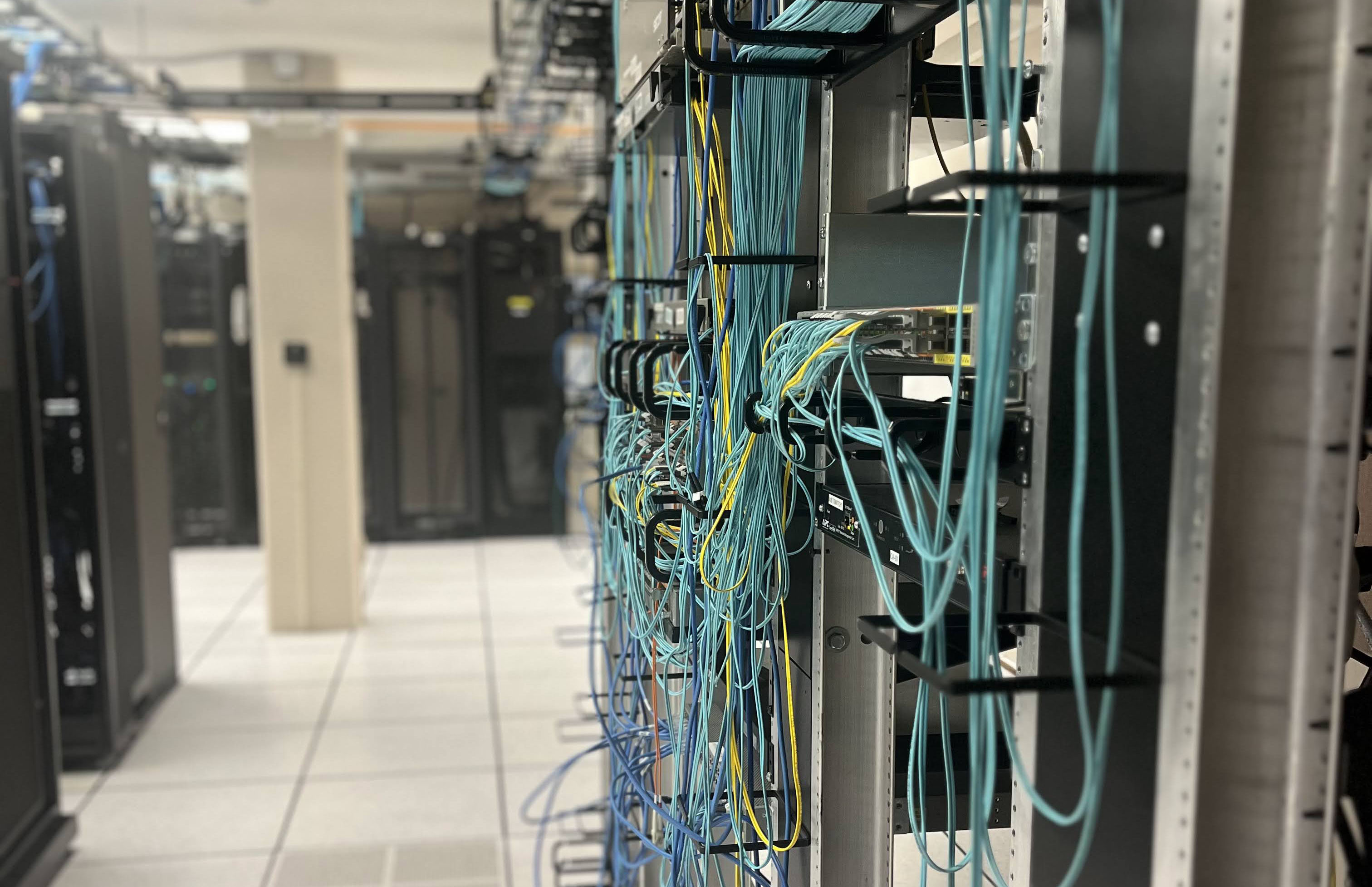 a jumble of blue network wires on a rack in the data center