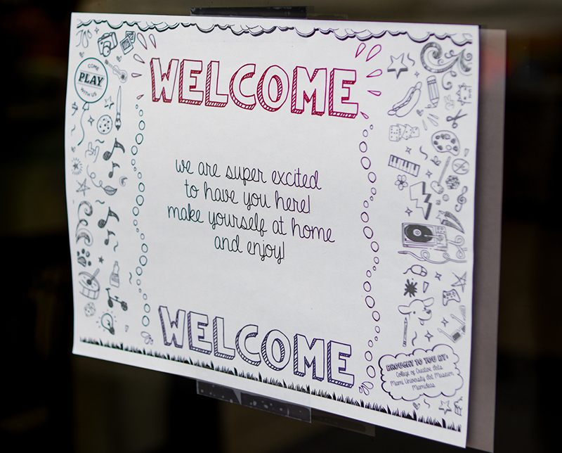 A white sign on a door that says Welcome