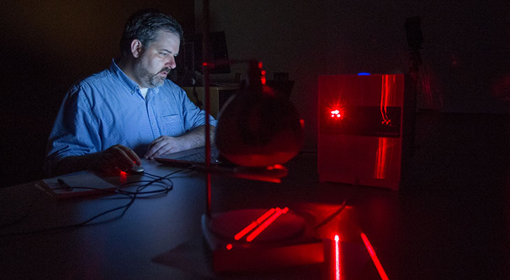 Jeb Card, visiting assistant professor of anthropology at Miami University, scans an artifact in his lab using 3-D technology.