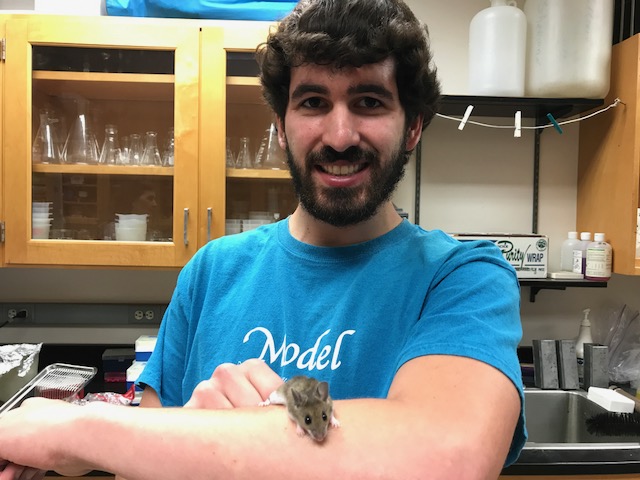 Jeremy holds the white mouse.