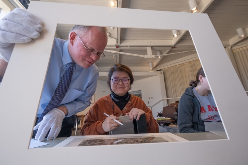 Bob Wicks, director of the Miami University Art Museum, helps a student during a recent class visit.