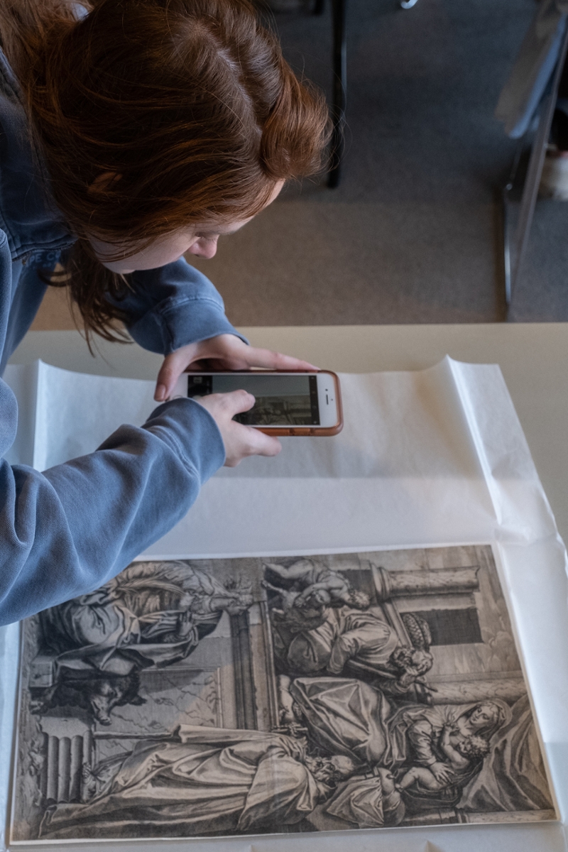 A Miami art history student takes a picture of a print piece from above.