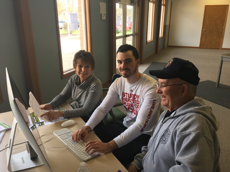 A Miami student sits at a computer with two Reily Township residents.