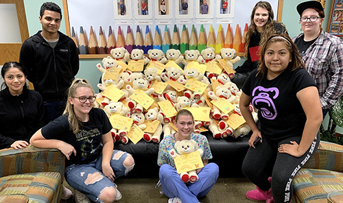 Several students with the bears they made to give to foster children