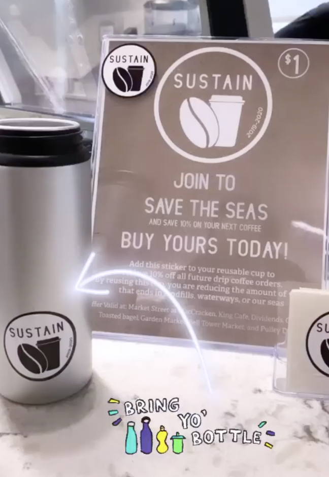 Sign about buying a Sustain Sticker for one dollar to save the seas and a reusable cup with the sticker on it