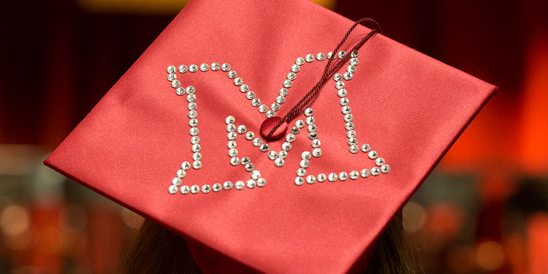 Red mortarboard with a Miami M jeweled on it