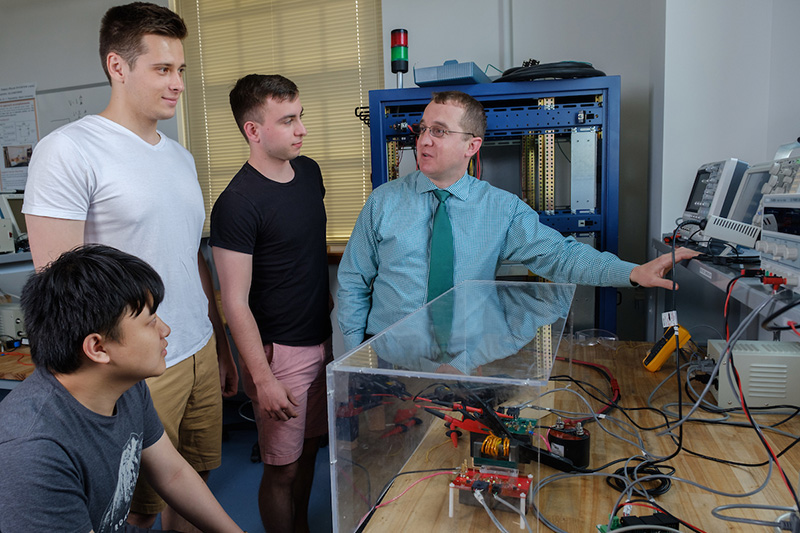 Mark Scott with 3 students in the power engineering lab