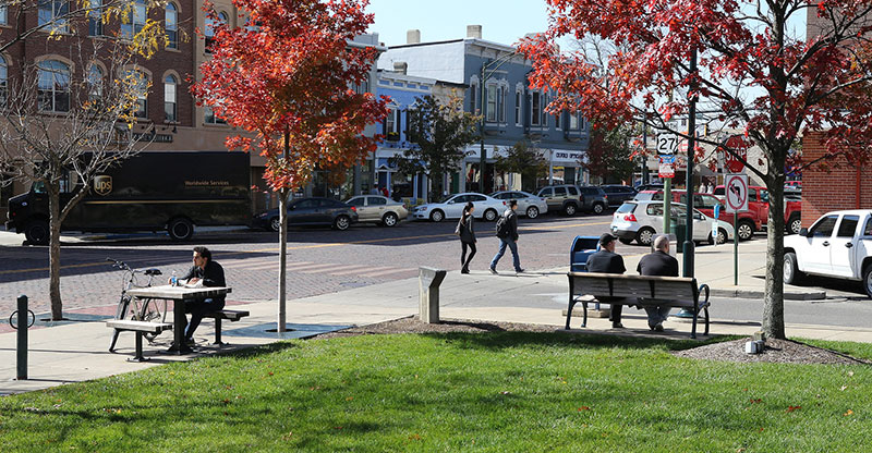 Man seated at picnic table in uptown Oxford