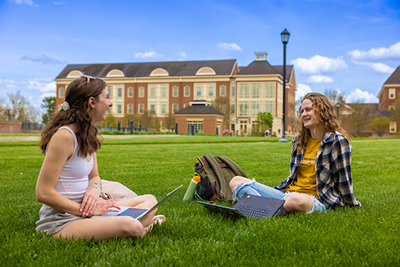 students sitting together on campus lawn