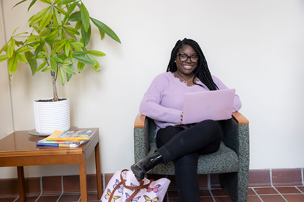 Lovia Osei sitting in a chair in McGuffey Hall