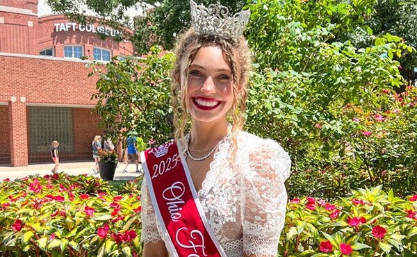 Amberly Szczerbiak wearing a red sash and crown of the Ohio Fair queen wearing a white lace dress