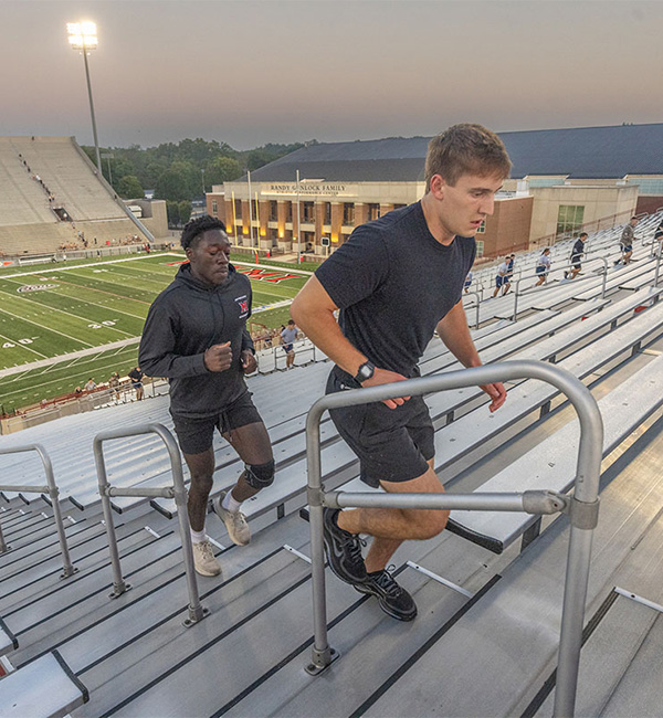two students climbing the stadium stairs at Yager stadium