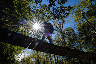 woman walking across a swinging bridge