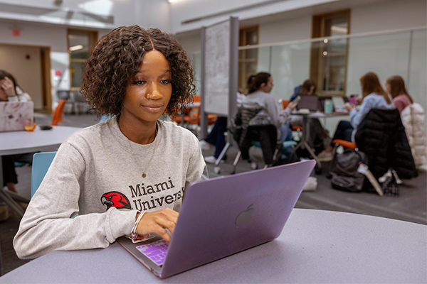 Student at a desk working on a laptop