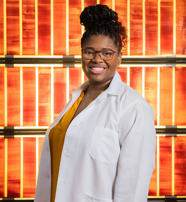 Engineer Lyndsey McMillon-Brown stands in front of solar cells at NASA’s Glenn Research Center