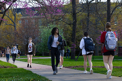students walking on a sidewalk on campus 