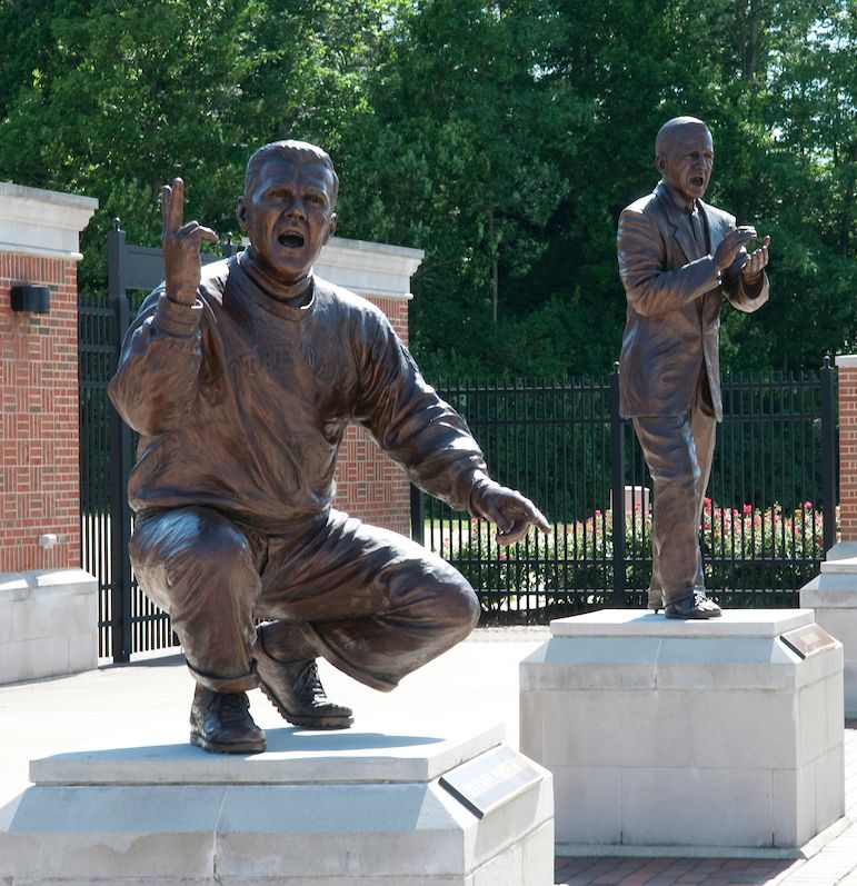 Bronze statues of Miami's iconic coaches lined up in front of the baseball stadium
