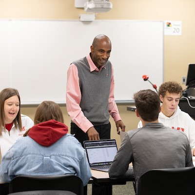 Faculty member teaching in a traditional style classroom