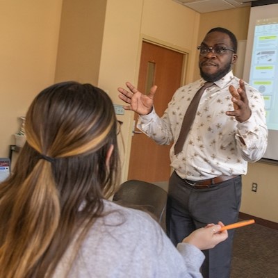 Faculty member teaching in a traditional style classroom