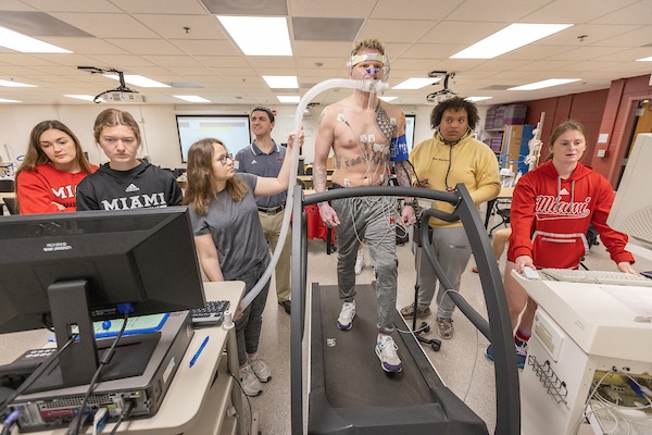 Kinesiology students performing research study using a treadmill and monitoring equipment to measure a student's atheltic performance