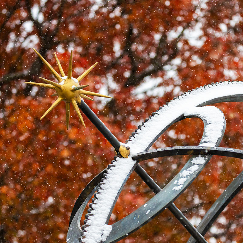 The Miami University bronze sundial statue dusted with snow