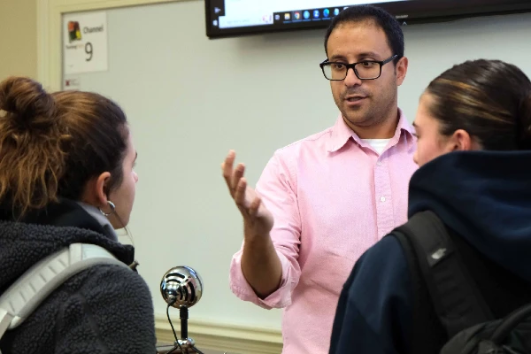 Fadel Megahed, faculty member in FSB, is talking to two students in a classroom.