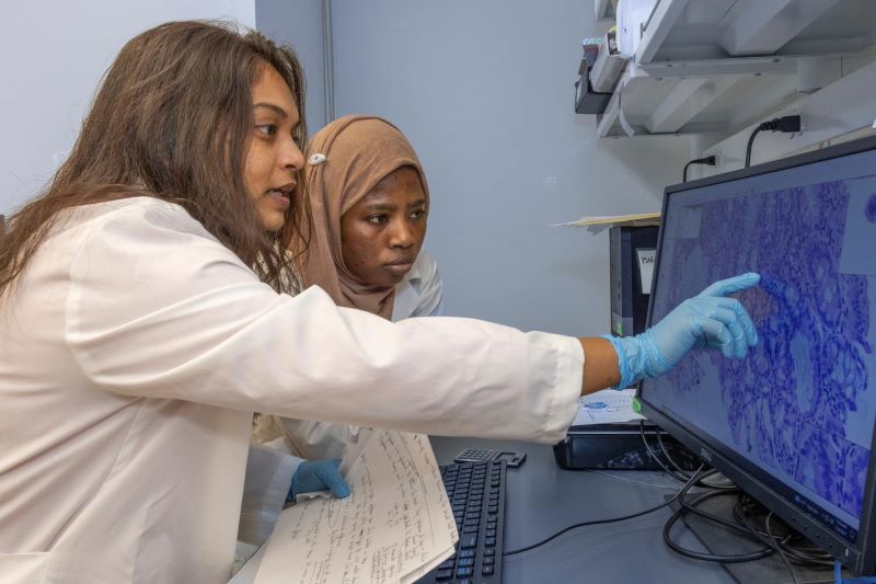 Female instructor working with a student in a lab.