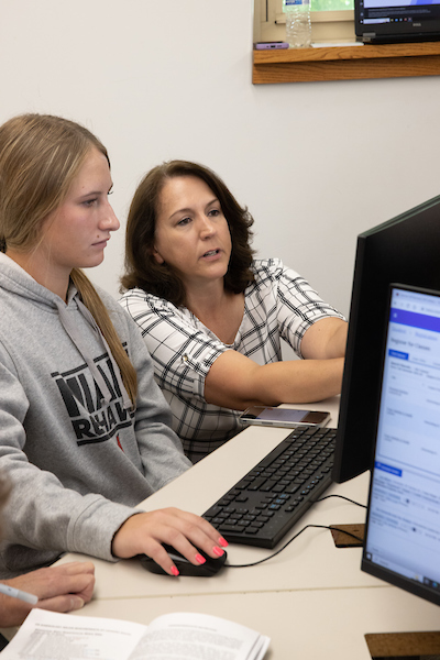 advisor working with student in a computer lab